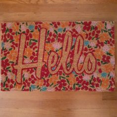 a door mat with the word hello kitty written on it and flowers all over it