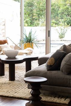 a living room with two couches and a table in front of the glass doors