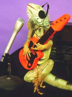 an iguana lizard with headphones, guitar and microphone in front of a purple background