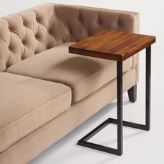 a couch with a wooden table sitting on it's back end next to a sofa