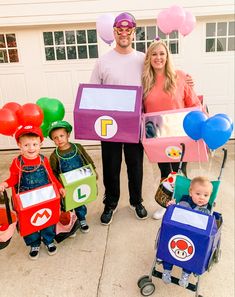 a man and woman with children dressed up in costumes that look like they are playing video games