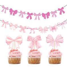 three cupcakes with pink bows on them are next to a bunting banner