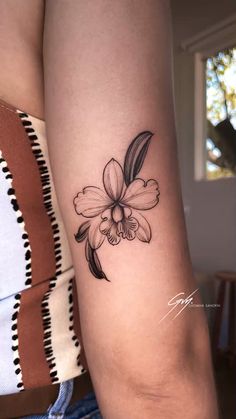 a woman's arm with a flower tattoo on the left side of her arm