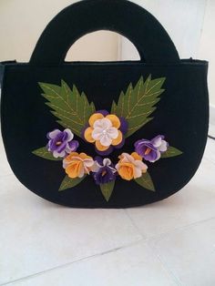 a black purse with flowers painted on it