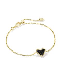 Wear your heart on your wrist with the Ari Heart Gold Delicate Chain Bracelet in Black Drusy. This asymmetrical design shines solo, but functions just as well as part of your everyday stack. Metal 14k Yellow Gold Over Brass Material Black Drusy Closure Lobster Clasp W/ Single Adjustable Slider Bead Size 7.5" Chain, 0.56"L X 0.37"W PendantDue to the one-of-a-kind nature of the medium, exact colors and patterns may vary slightly from the image shown. | Kendra Scott Ari Heart Gold Delicate Chain Bracelet in Black | Drusy Trendy Black Heart Bracelet As Gift, Black Heart Bracelets With Heart Charm, Kendra Scott Necklace Black, Black And Gold Kendra Scott, Black Heart Charm Bracelet, Kendra Scott Bracelet, Bar Jewelry, Vanilla Girl, Black Pendant