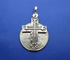 a silver cross pendant on a blue background