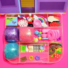 a pink plastic tray filled with lots of toys and accessories on top of a table