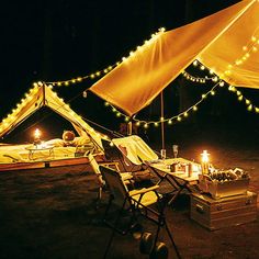 a tent with lights and chairs in the dark