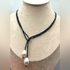 a necklace with pearls and black beads on a mannequin