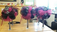 three vases with pink and black bows on them sitting on a table in front of a window