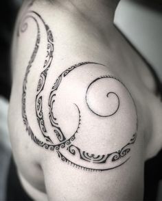 a black and white photo of a man's shoulder with an intricate tattoo design on it