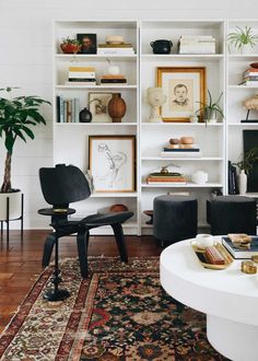 a living room filled with lots of furniture and bookshelves above a white coffee table