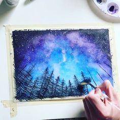 someone is painting the night sky with watercolors