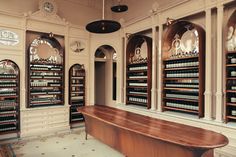 a large wooden bench sitting in front of a wall filled with shelves full of bottles