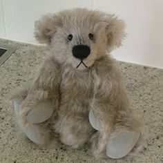 a stuffed teddy bear sitting on top of a counter