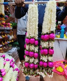 a man is holding up some flowers in front of him