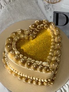 a golden heart shaped cake sitting on top of a plate