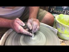 a man is making something out of clay on a potter's wheel with his hands