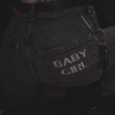 the back of a woman's jean shorts with baby girl written on it and a pair of handcuffs hanging from her waist