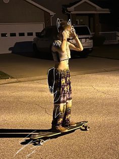 a young man riding a skateboard on top of a driveway next to a house