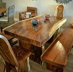 a wooden table with two chairs and a bowl on top of it in a room