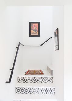 the stairs are painted white and have black handrails with decorative tiles on them