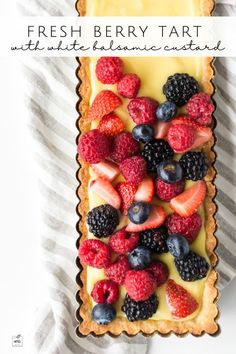 fresh berry tart with lemon custard and berries in the middle on a striped napkin