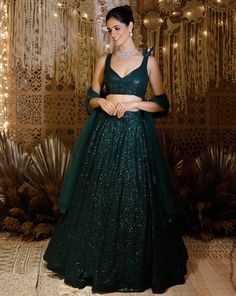 This outfit adds the shimmer of sequences to the deepness of green. The sequence lehenga has an embroidered 3D shoulder broach. Colour : Green Fabric : Georgette blouse Embroidery : Components : 3. Lehenga, Blouse, Dupatta Delivery : 28 days Dark Green Colour Lehenga, Gowns Dresses For Reception, Dark Green Lehenga Designs, Lehenga Designs Sleeveless, Sequin Lehenga Indian Weddings, Dark Colour Lehenga, Dark Green Lehenga Combination, Dark Green Lengha, Shimmer Lehenga Sequins