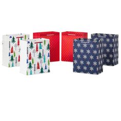 four christmas gift bags with trees and snowflakes on them, all lined up against a white background