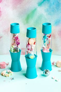 three blue vases filled with candy and candies