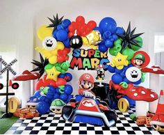 the balloon arch is decorated with mario kart characters and balloons that spell out super mario