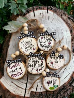 six decorated cookies sitting on top of a tree stump