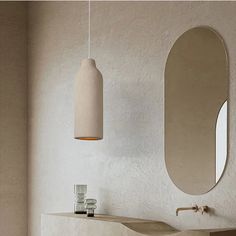 a bathroom with a sink, mirror and vase on the counter next to each other