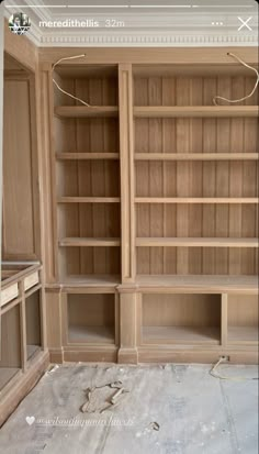 an empty bookcase in the middle of a room with no furniture on it,