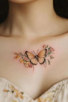 a woman's chest with a butterfly and flowers tattoo on her left side shoulder