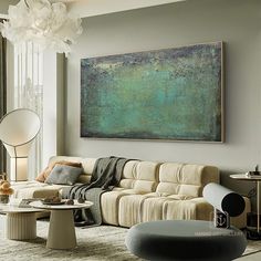 a living room filled with furniture and a large painting hanging on the wall above it