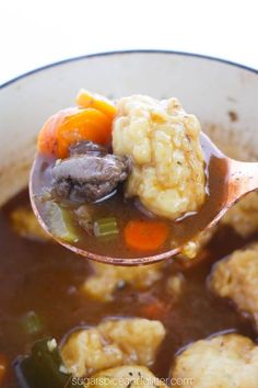 a spoon full of stew with meat and vegetables