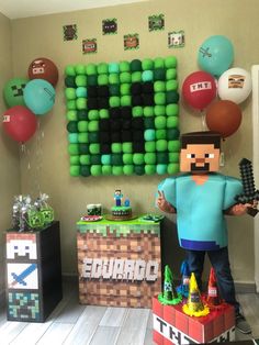 a man standing in front of a wall with balloons on it and an image of a video game character