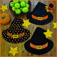 a wooden table topped with witches hats and apples