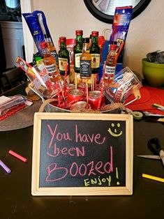 a chalkboard with the words you have been boozed enjoy written on it in front of some condiments