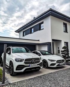 two mercedes benz cars parked in front of a house