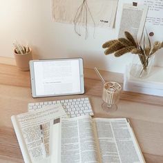 an open book sitting on top of a desk next to a laptop computer and tablet