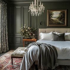 a bedroom with green walls and a chandelier hanging from the ceiling over a bed