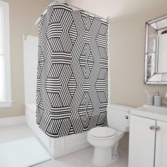 a black and white shower curtain in a bathroom next to a toilet with the lid up