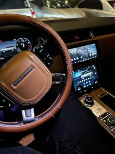 the interior of a car with dashboard, steering wheel and digital display showing cars in the background