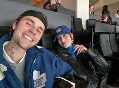 a man and woman sitting next to each other in front of an audience at a sporting event