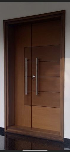 an open wooden door with metal handles