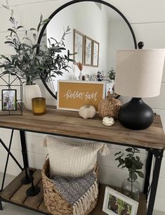 a wooden table topped with a mirror next to a plant