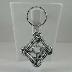 a metal keychain with an intricate design on it