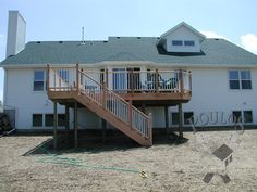 a large white house with a deck and stairs